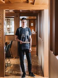 Auszubildender im Service bringt Wein und Wasser im Restaurant des Hotel Adler.