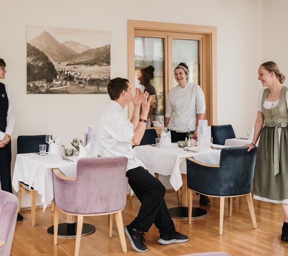 Junges Team im Hotel Adler beim lockeren Austausch im Restaurant.